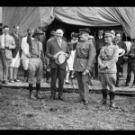 Reenactment of Pickett's Charge at the battle of Gettysburg in Pennsylvania. Smedley Butler, President Warren Harding, John J. Pershing, and John Archer Lejeune in front of canvas "White House"